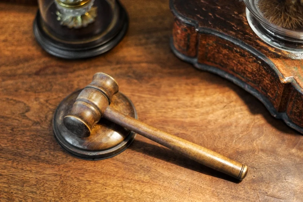 Un maillet en bois de juge est couché sur un bureau en bois massif